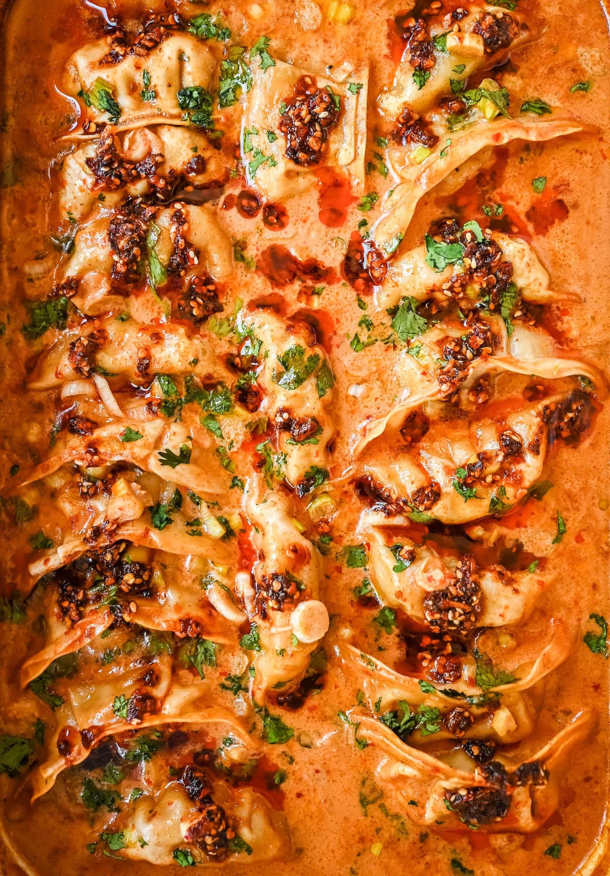These viral baked dumplings from TikTok are the ultimate easy dinner hack! Crispy dumplings are baked in a creamy coconut curry sauce and topped with cilantro, chili crunch oil, and sesame seeds for the perfect mix of flavor and texture. This is an easy sheet pan dinner recipe!