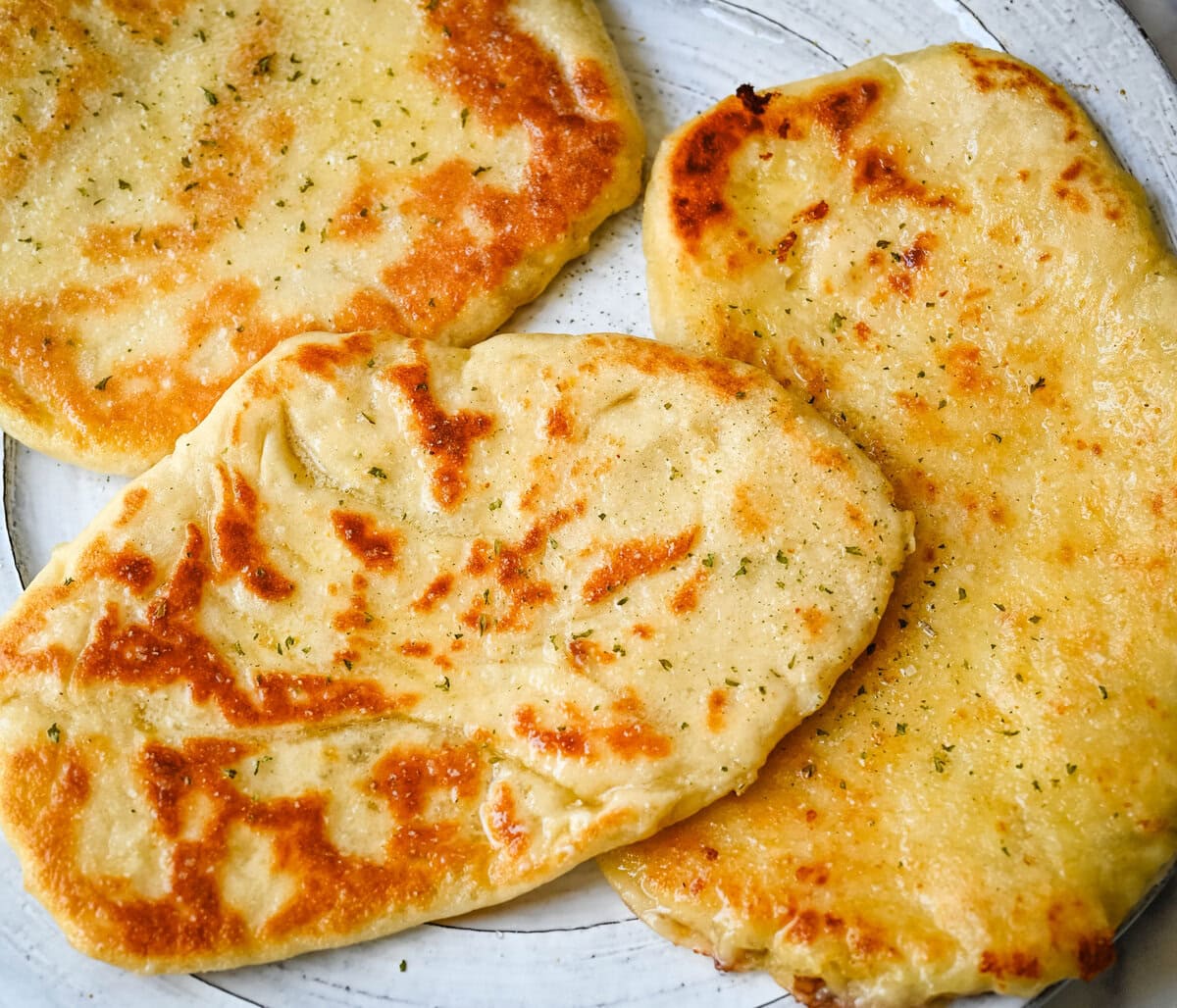 Homemade Cheesy Naan bread stuffed with mozzarella cheese, that is even better than what you find in restaurants. Cheese-stuffed naan is soft, slightly chewy, golden-brown on the outside, fluffy bread layers inside, and melty gooey cheese in the center.