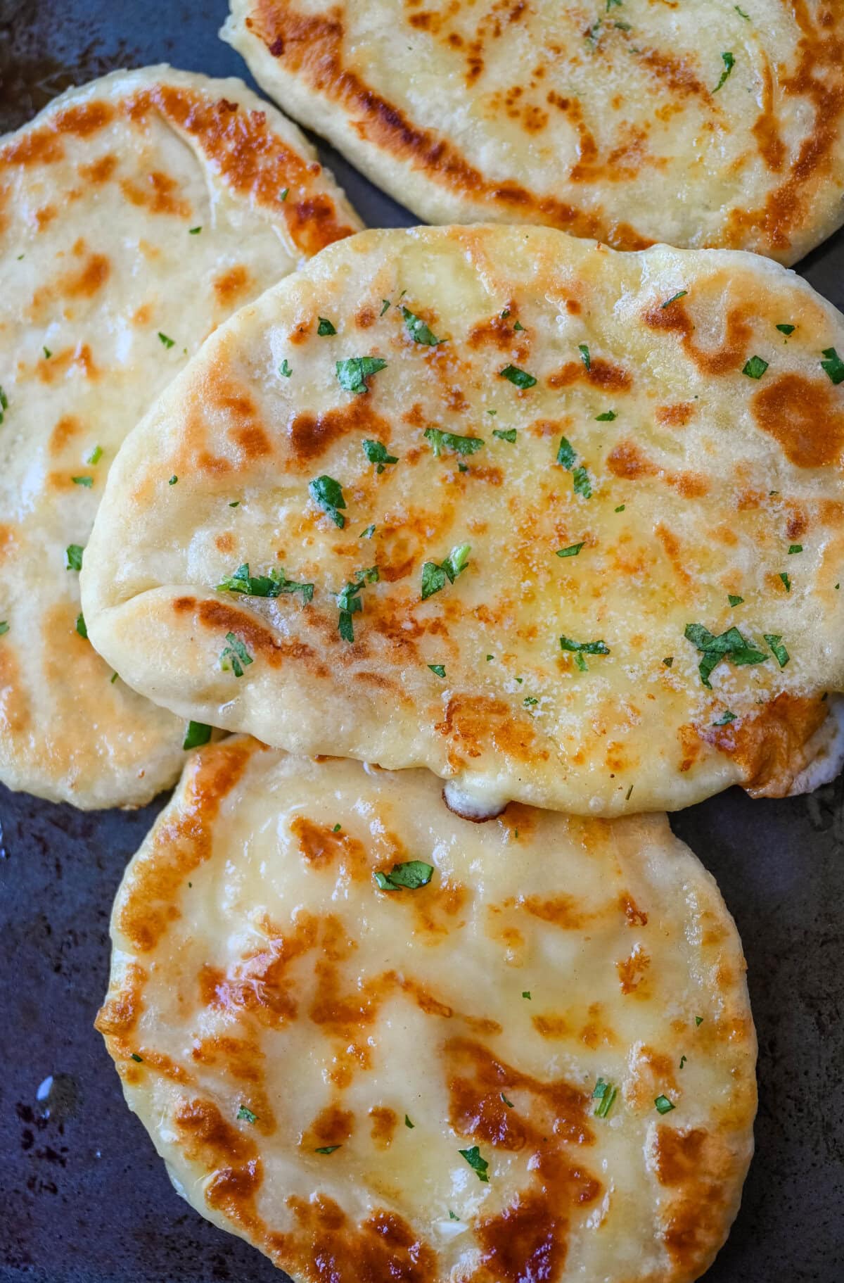 Homemade Cheesy Naan bread stuffed with mozzarella cheese, that is even better than what you find in restaurants. Cheese-stuffed naan is soft, slightly chewy, golden-brown on the outside, fluffy bread layers inside, and melty gooey cheese in the center.