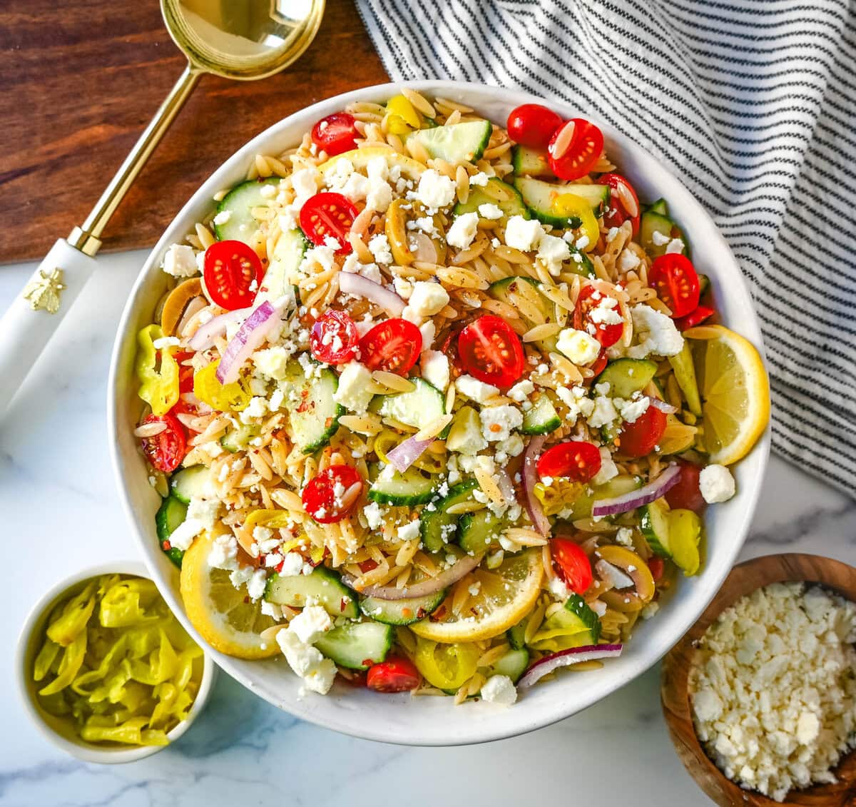 Fresh Mediterranean Orzo Salad made with a bright greek oregano dressing, orzo pasta, crisp cucumber, cherry tomatoes, red onion, feta cheese, and pepperoncinis. This greek orzo pasta salad recipe is perfect for summer or meal prep!