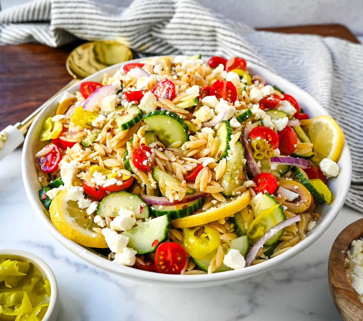 Fresh Mediterranean Orzo Salad made with a bright greek oregano dressing, orzo pasta, crisp cucumber, cherry tomatoes, red onion, feta cheese, and pepperoncinis. This greek orzo pasta salad recipe is perfect for summer or meal prep!