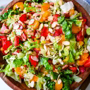 A fresh strawberry mandarin orange salad with candied almonds is the perfect summer side dish! Sweet strawberries, mandarin oranges, crunchy candied almonds, and a light homemade dressing.