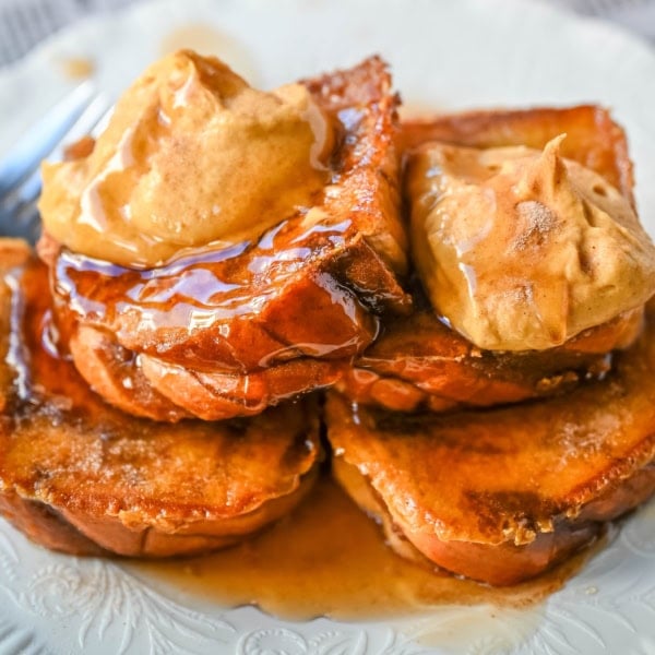 This Pumpkin French Toast is the perfect fall breakfast! Made with pumpkin puree, pumpkin spice, and thick slices of brioche cinnamon bread, it’s golden on the outside, soft inside, and topped with a dollop of sweet brown sugar pumpkin spice cream cheese.