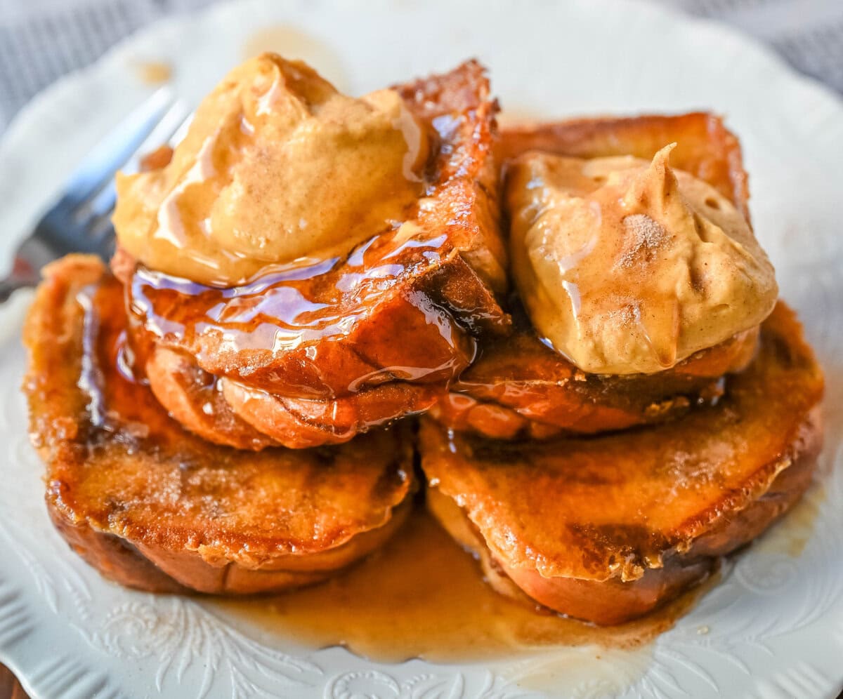This Pumpkin French Toast is the perfect fall breakfast! Made with pumpkin puree, pumpkin spice, and thick slices of brioche cinnamon bread, it’s golden on the outside, soft inside, and topped with a dollop of sweet brown sugar pumpkin spice cream cheese.