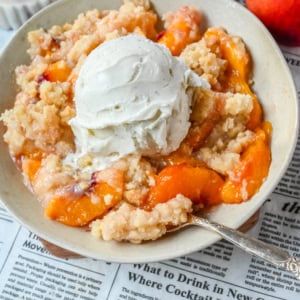 This Homemade Sugar Cookie Peach Cobbler is made with juicy peaches tossed in sugar and topped with a soft, buttery sugar cookie crust, then baked until golden. Serve it warm with a scoop of vanilla ice cream for the best peach cobbler recipe with a sugar cookie twist!