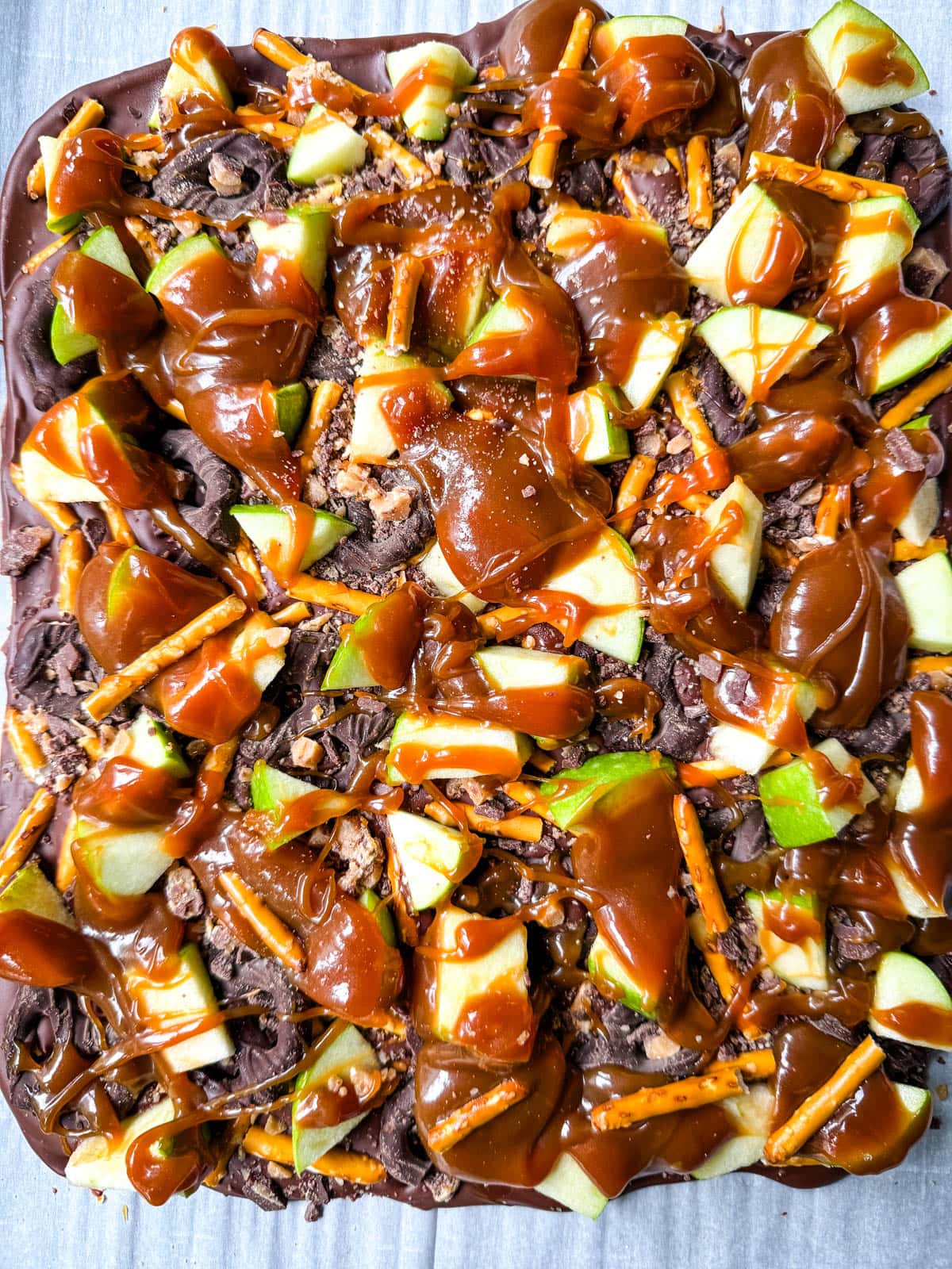 This Caramel Apple Bark is an easy no-bake Fall treat and made with fresh apples, buttery caramel, crunchy pretzels, and rich chocolate. This quick and easy Fall dessert is absolutely delicious and a crowd favorite!