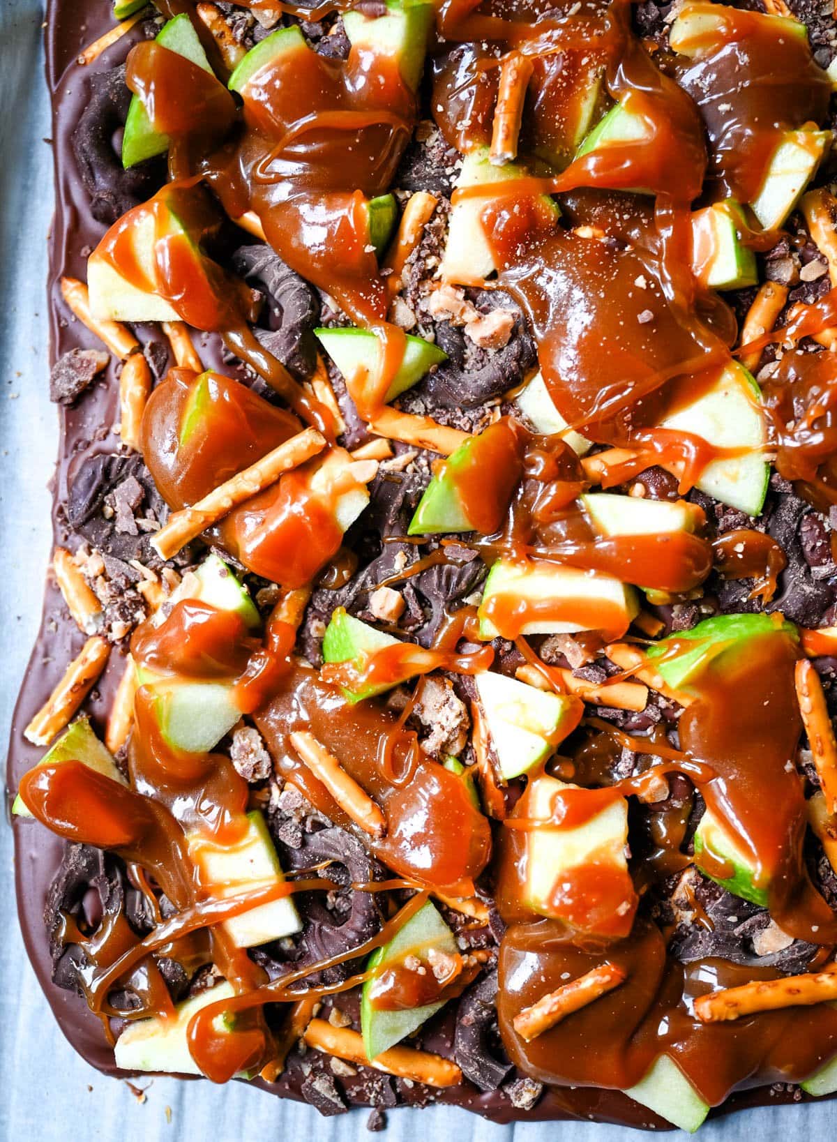 This Caramel Apple Bark is an easy no-bake Fall treat and made with fresh apples, buttery caramel, crunchy pretzels, and rich chocolate. This quick and easy Fall dessert is absolutely delicious and a crowd favorite!