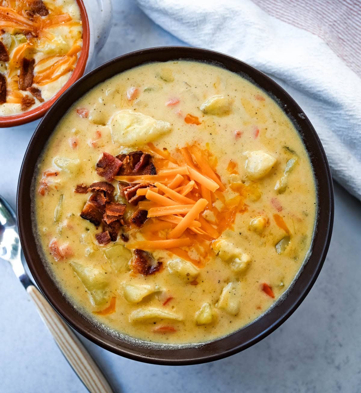 This creamy potato soup is the definition of comfort in a bowl made with buttery Yukon gold potatoes, crispy bacon, cheddar cheese, and a splash of heavy cream come together to make the richest, coziest soup ever. You will love this Potato Cheese Soup Recipe!