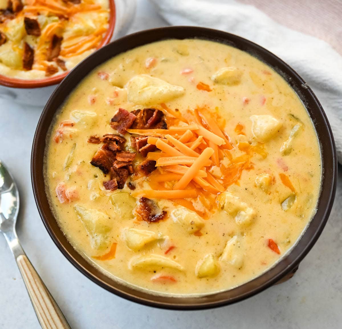 This creamy potato soup is the definition of comfort in a bowl made with buttery Yukon gold potatoes, crispy bacon, cheddar cheese, and a splash of heavy cream come together to make the richest, coziest soup ever. You will love this Potato Cheese Soup Recipe!