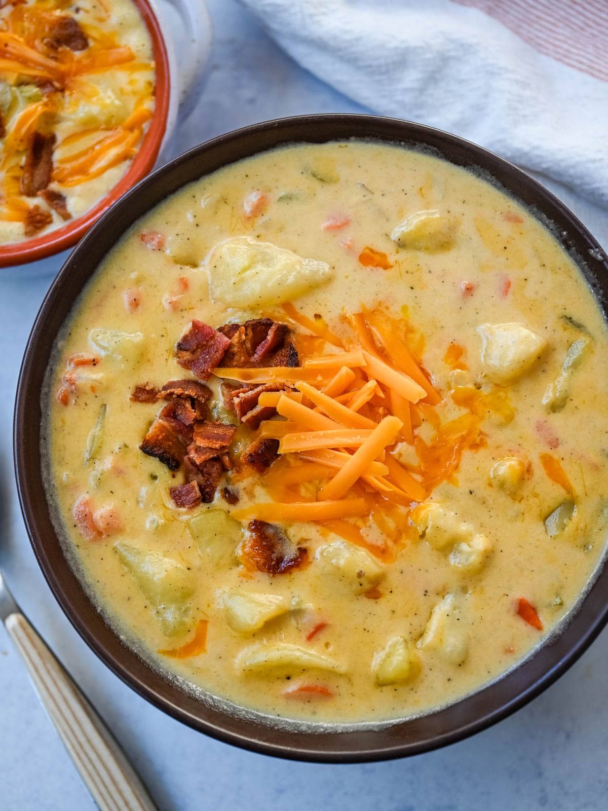 This creamy potato soup is the definition of comfort in a bowl made with buttery Yukon gold potatoes, crispy bacon, cheddar cheese, and a splash of heavy cream come together to make the richest, coziest soup ever. You will love this Potato Cheese Soup Recipe!