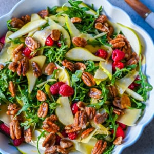 This easy arugula salad with pears and candied pecans is a show-stopping salad that’s perfect for entertaining. The delicious combination of peppery greens, sweet fruit, creamy cheese, crunchy nuts and a zesty homemade vinaigrette that ties it all together. It’s a salad that feels special enough for the holidays but simple enough for a weeknight dinner.