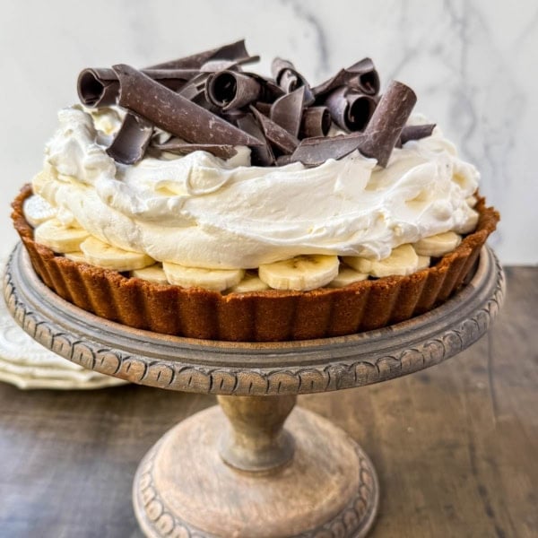 This classic banoffee pie is a no-bake dessert made with a buttery graham cracker or Biscoff cookie crust, rich toffee caramel, fresh bananas, and fluffy whipped cream. It’s a holiday dessert that delivers big flavor with no oven and minimal prep.