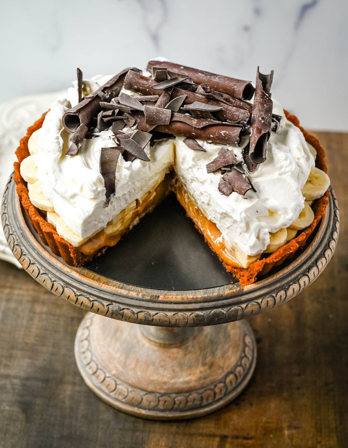 This classic banoffee pie is a no-bake dessert made with a buttery graham cracker or Biscoff cookie crust, rich toffee caramel, fresh bananas, and fluffy whipped cream. It’s a holiday dessert that delivers big flavor with no oven and minimal prep.