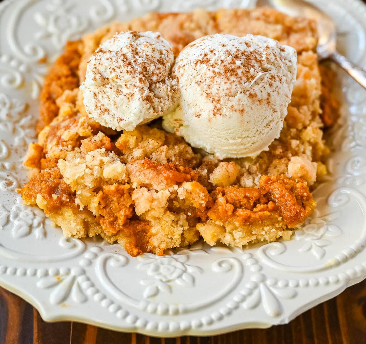 This Pumpkin Cobbler recipe is made with a creamy, rich spiced pumpkin filling and then topped with a sweet, buttery crumble. This Pumpkin Crisp recipe is so easy to make! An easy Fall and Thanksgiving dessert.