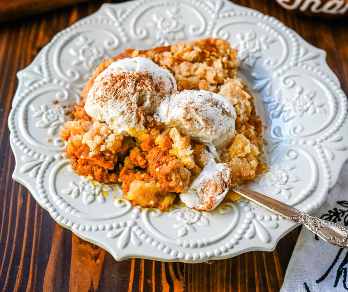 This Pumpkin Cobbler recipe is made with a creamy, rich spiced pumpkin filling and then topped with a sweet, buttery crumble. This Pumpkin Crisp recipe is so easy to make! An easy Fall and Thanksgiving dessert.