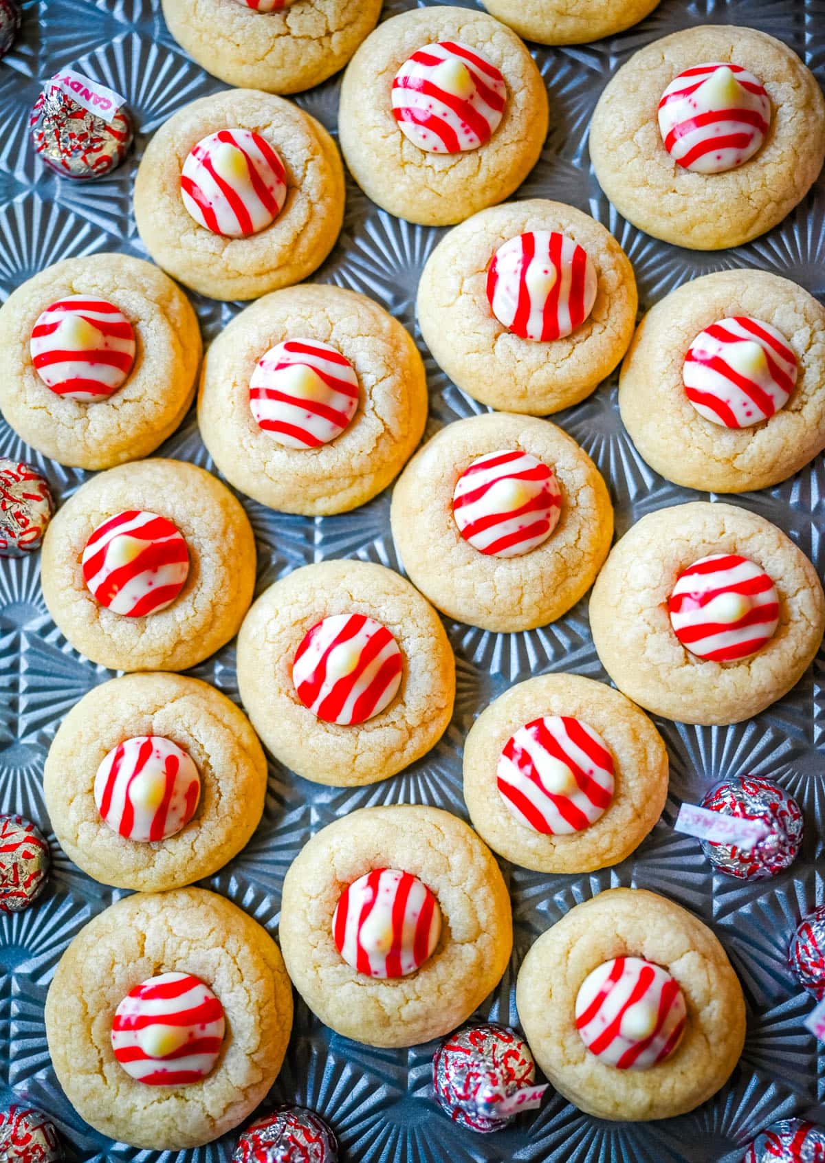 These Candy Cane Kiss Cookies are soft, buttery sugar cookies rolled in sparkling sugar or festive sprinkles, baked until just set, and then pressed with a striped peppermint Candy Cane Kiss right in the center. This Peppermint Kiss Cookie is such a festive Christmas cookie recipe.