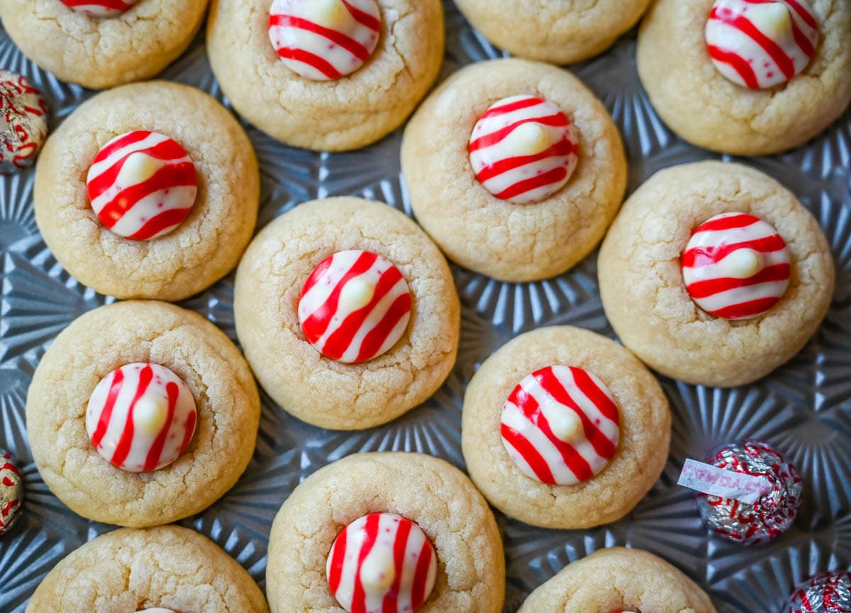 These Candy Cane Kiss Cookies are soft, buttery sugar cookies rolled in sparkling sugar or festive sprinkles, baked until just set, and then pressed with a striped peppermint Candy Cane Kiss right in the center. This Peppermint Kiss Cookie is such a festive Christmas cookie recipe.