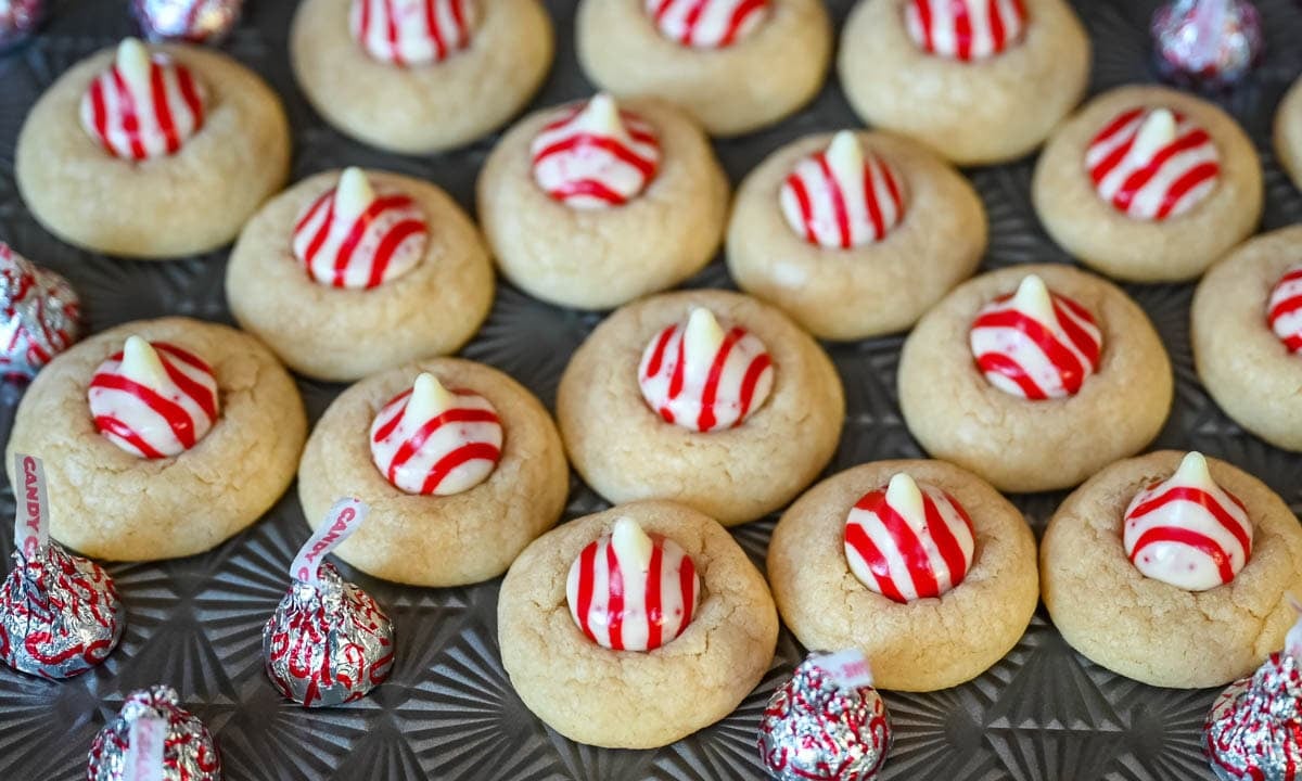 These Candy Cane Kiss Cookies are soft, buttery sugar cookies rolled in sparkling sugar or festive sprinkles, baked until just set, and then pressed with a striped peppermint Candy Cane Kiss right in the center. This Peppermint Kiss Cookie is such a festive Christmas cookie recipe.