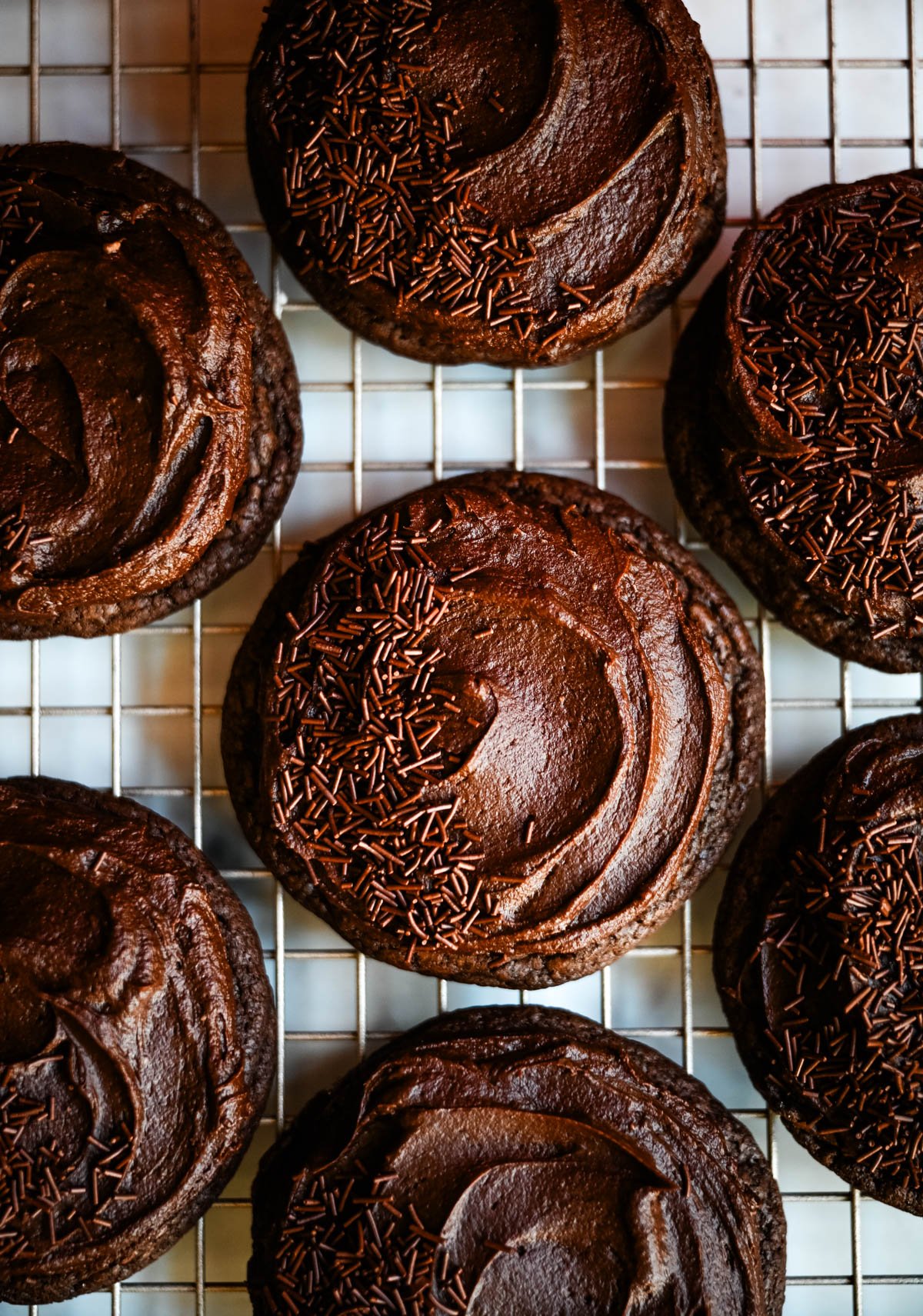 These easy Chocolate Frosted Cookies combine soft chocolate cookies with a rich, chocolate buttercream frosting. The double chocolate cookie base is filled with melty chocolate chips and a smooth cocoa frosting on top. These Frosted Chocolate Cookies are a chocolate lover’s dream.