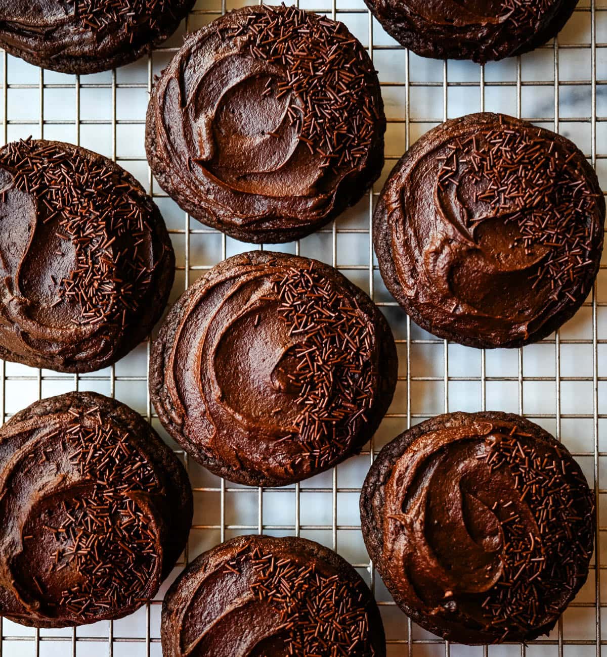 These easy Chocolate Frosted Cookies combine soft chocolate cookies with a rich, chocolate buttercream frosting. The double chocolate cookie base is filled with melty chocolate chips and a smooth cocoa frosting on top. These Frosted Chocolate Cookies are a chocolate lover’s dream.