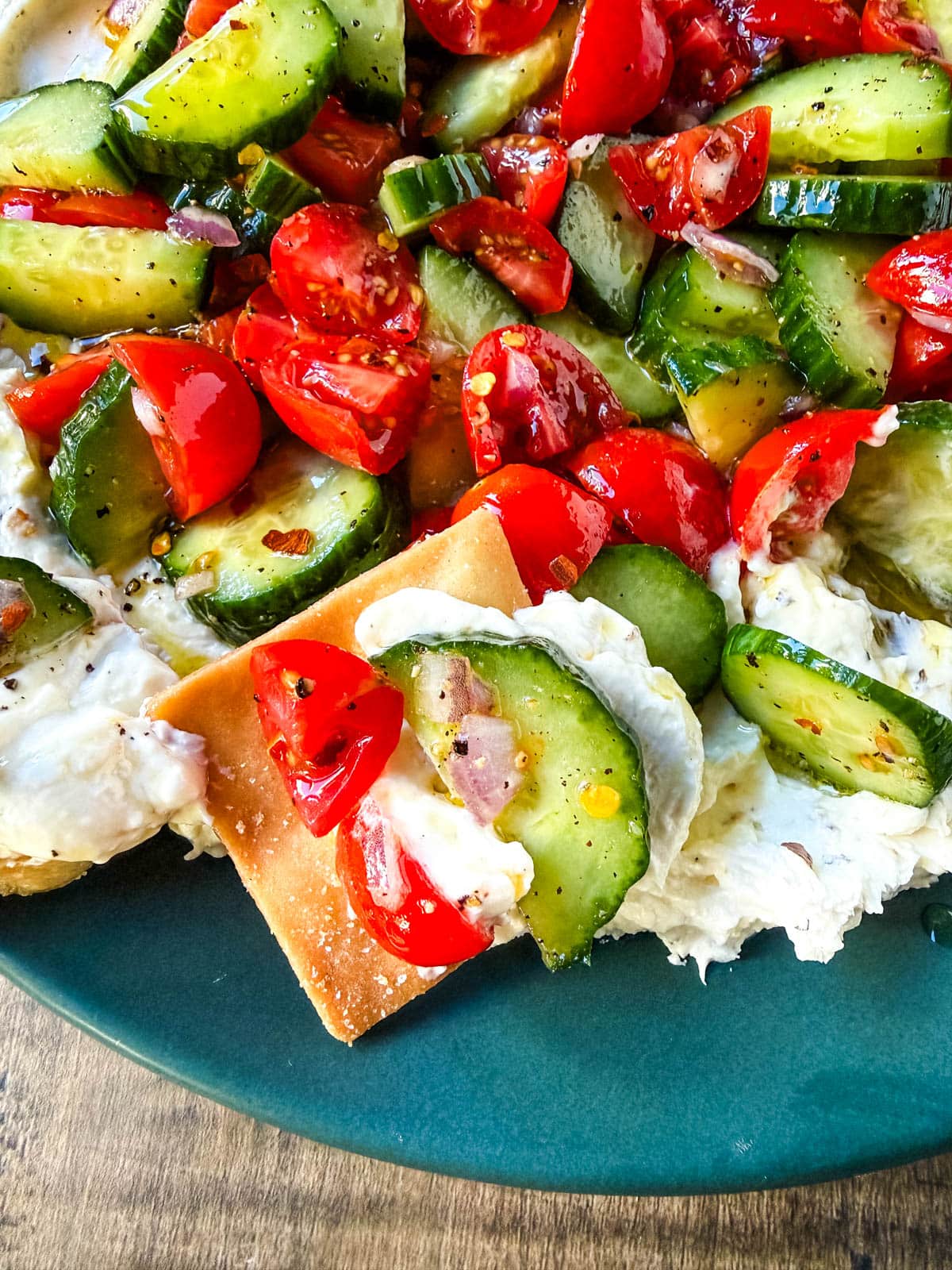 This Greek feta dip is the ultimate party and holiday appetizer that is rich, creamy, and so flavorful! It blends tangy feta, cream cheese, lemon, oregano, and olive oil into a silky whipped dip that feels fancy but takes just minutes to make. Pile it high with tomatoes, cucumbers, and a drizzle of olive oil, then serve with pita chips or veggies.