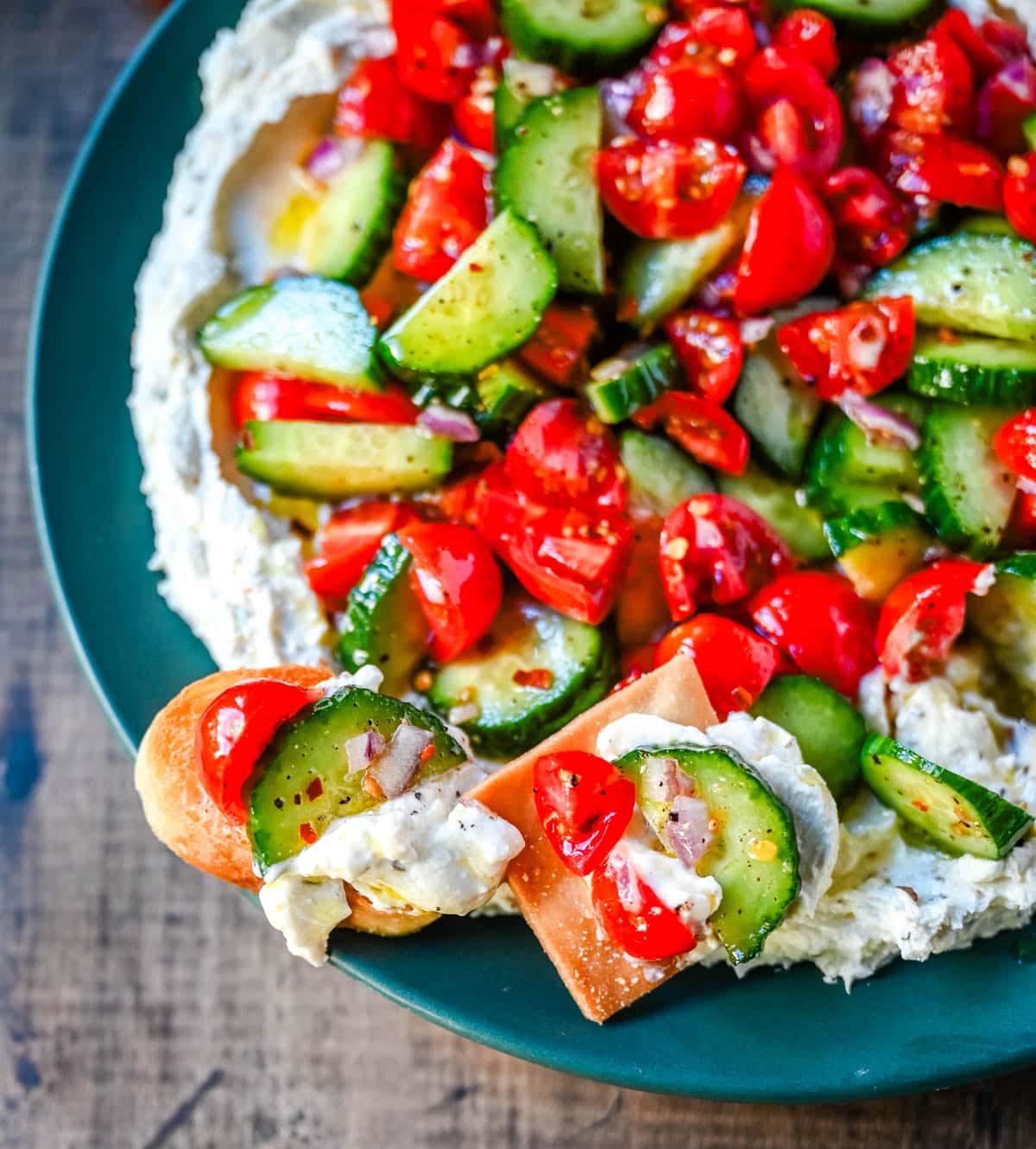 This Greek feta dip is the ultimate party and holiday appetizer that is rich, creamy, and so flavorful! It blends tangy feta, cream cheese, lemon, oregano, and olive oil into a silky whipped dip that feels fancy but takes just minutes to make. Pile it high with tomatoes, cucumbers, and a drizzle of olive oil, then serve with pita chips or veggies.