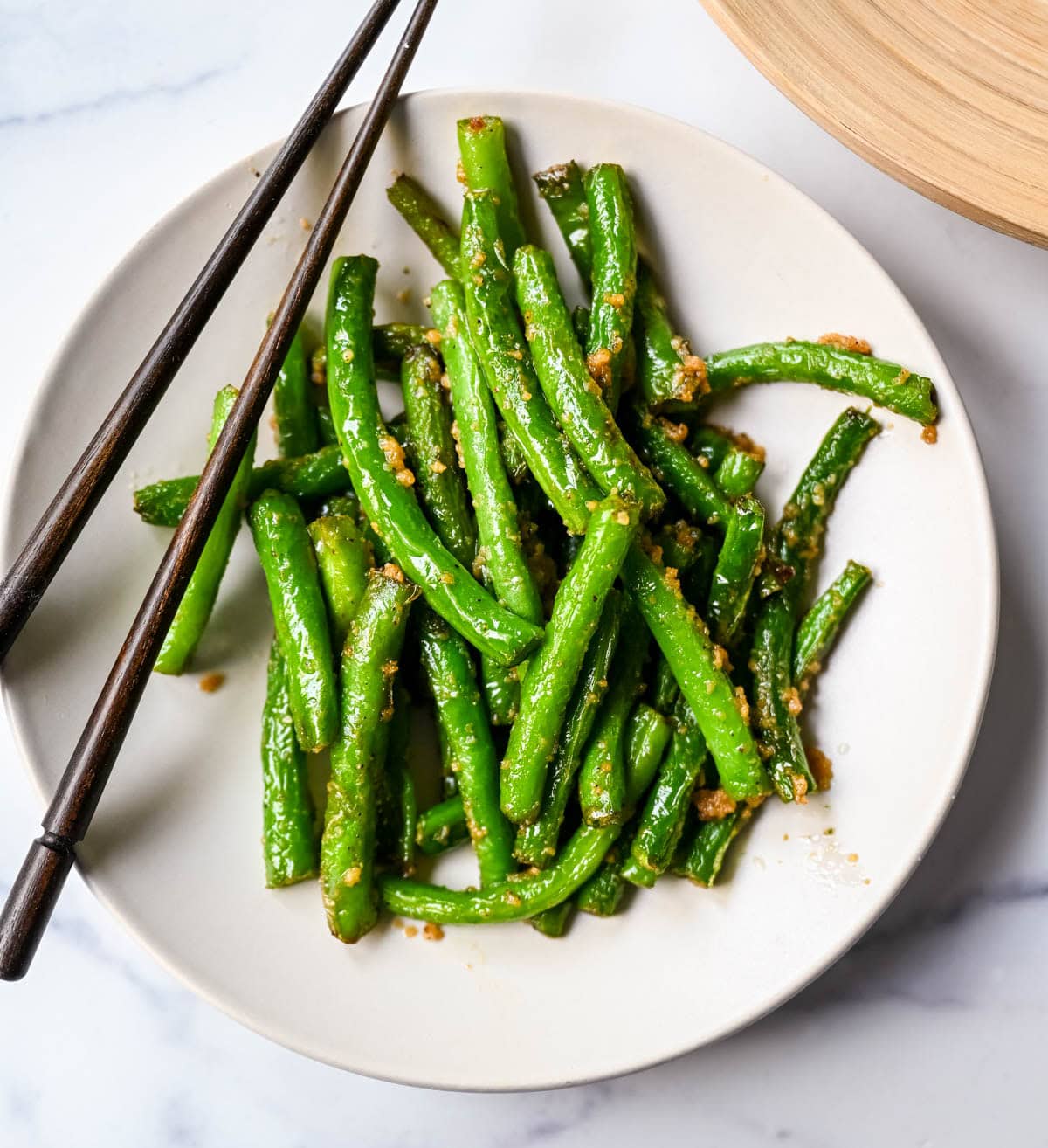 These Din Tai Fung green beans are crispy, blistered, and tossed with fresh garlic just like the famous restaurant version. A Chinese vegetable side dish that pairs perfectly with dumplings, noodles, or rice. The best copycat Din Tai Fung garlic green beans recipe!