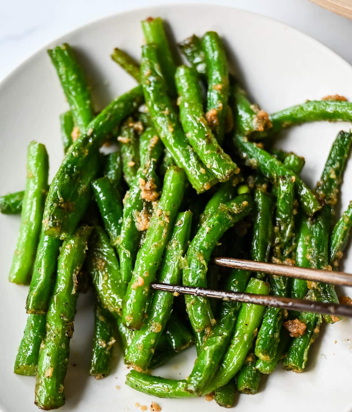These Din Tai Fung green beans are crispy, blistered, and tossed with fresh garlic just like the famous restaurant version. A Chinese vegetable side dish that pairs perfectly with dumplings, noodles, or rice. The best copycat Din Tai Fung garlic green beans recipe!