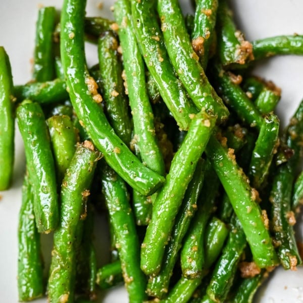 These Din Tai Fung green beans are crispy, blistered, and tossed with fresh garlic just like the famous restaurant version. A Chinese vegetable side dish that pairs perfectly with dumplings, noodles, or rice. The best copycat Din Tai Fung garlic green beans recipe!