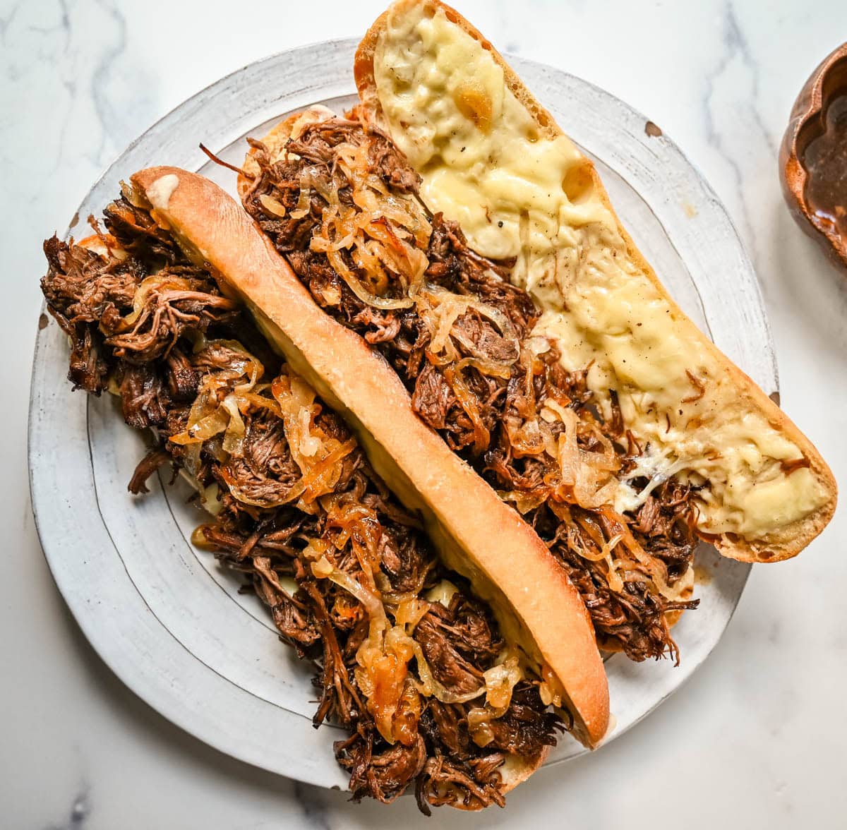This easy slow cooker French dip sandwich recipe features tender beef, savory au jus, caramelized onions, and melted provolone cheese. Finished with a creamy horseradish aioli, it’s a restaurant-quality sandwich made right at home.