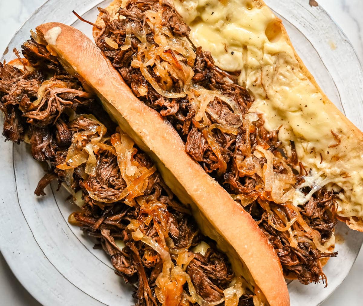 This easy slow cooker French dip sandwich recipe features tender beef, savory au jus, caramelized onions, and melted provolone cheese. Finished with a creamy horseradish aioli, it’s a restaurant-quality sandwich made right at home.