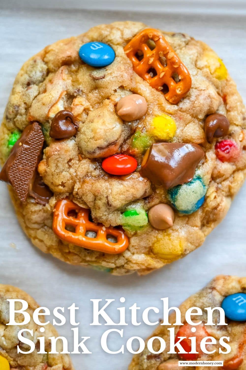 These Kitchen Sink Cookies are thick, soft, and chewy bakery-style cookies packed with chocolate chips, colorful M&M’s, crunchy pretzels, buttery toffee bits, and gooey caramel or peanut butter chips. Every bite is sweet, salty, crunchy, and chocolatey all at once. They’re called “kitchen sink” cookies because you can throw in everything but the kitchen sink, making them one of the most versatile and fully loaded cookie recipes you’ll ever bake.