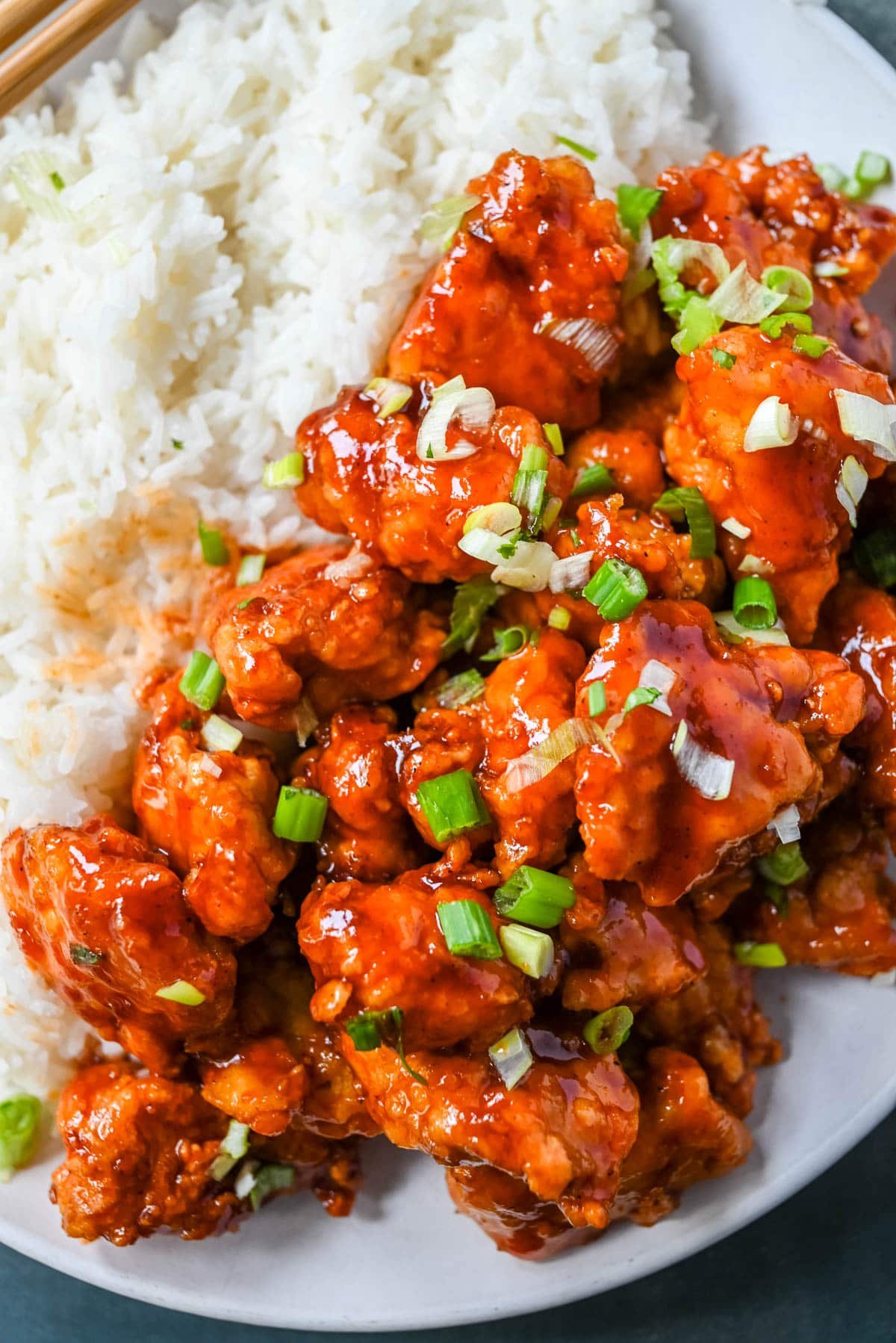 This homemade Honey Sriracha Chicken features tender chicken pieces fried until crispy and covered in a sticky honey sriracha glaze. The combination of honey, garlic, soy sauce, and sriracha creates the ultimate sweet heat flavor. This sticky chicken is way better than takeout!