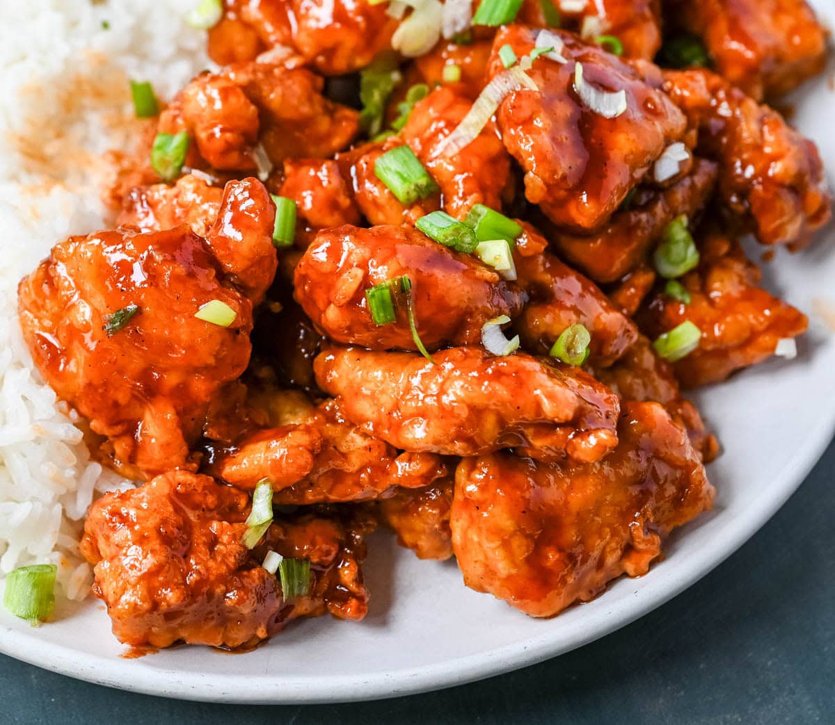 This homemade Honey Sriracha Chicken features tender chicken pieces fried until crispy and covered in a sticky honey sriracha glaze. The combination of honey, garlic, soy sauce, and sriracha creates the ultimate sweet heat flavor. This sticky chicken is way better than takeout!