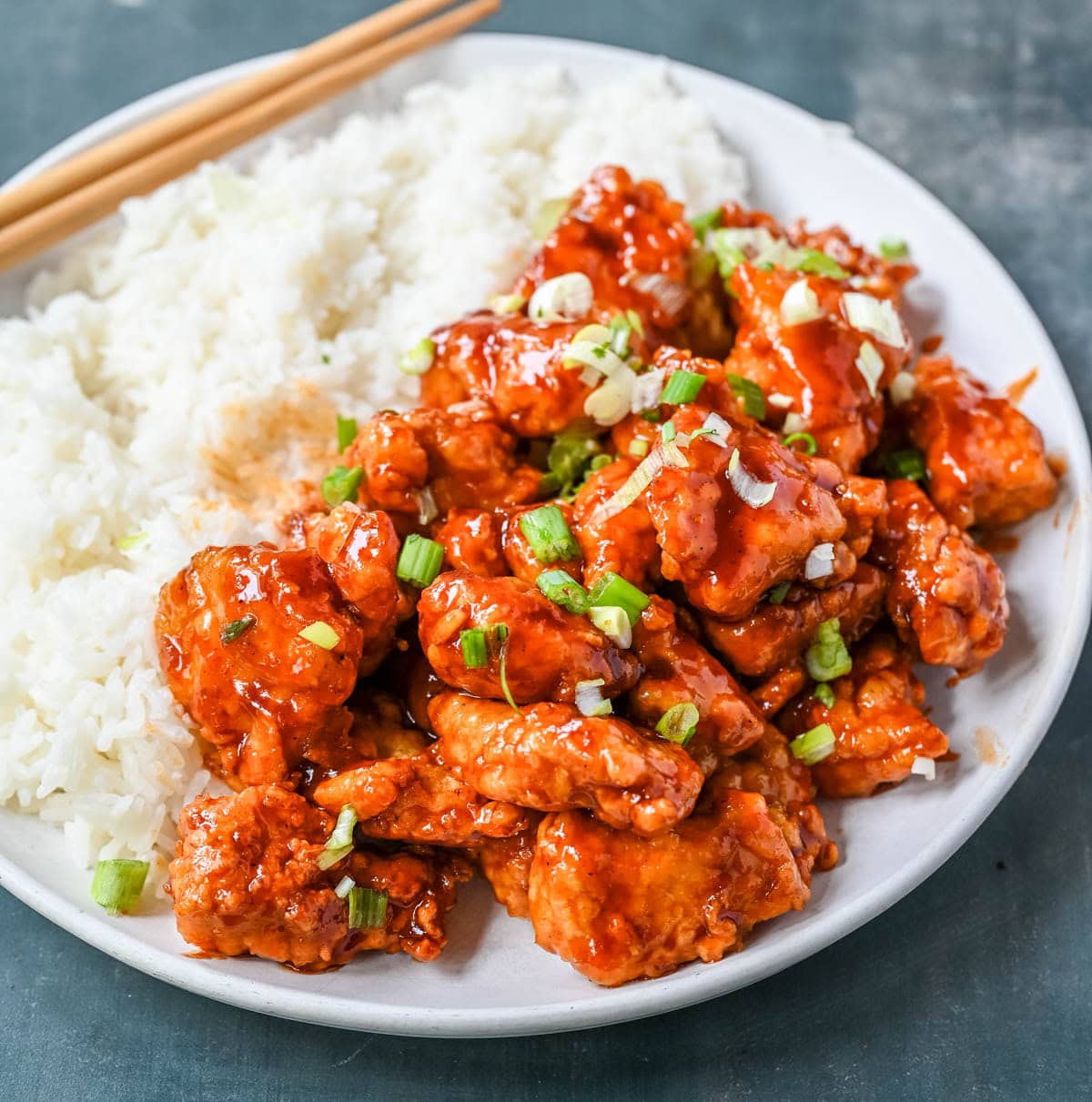 This homemade Honey Sriracha Chicken features tender chicken pieces fried until crispy and covered in a sticky honey sriracha glaze. The combination of honey, garlic, soy sauce, and sriracha creates the ultimate sweet heat flavor. This sticky chicken is way better than takeout!
