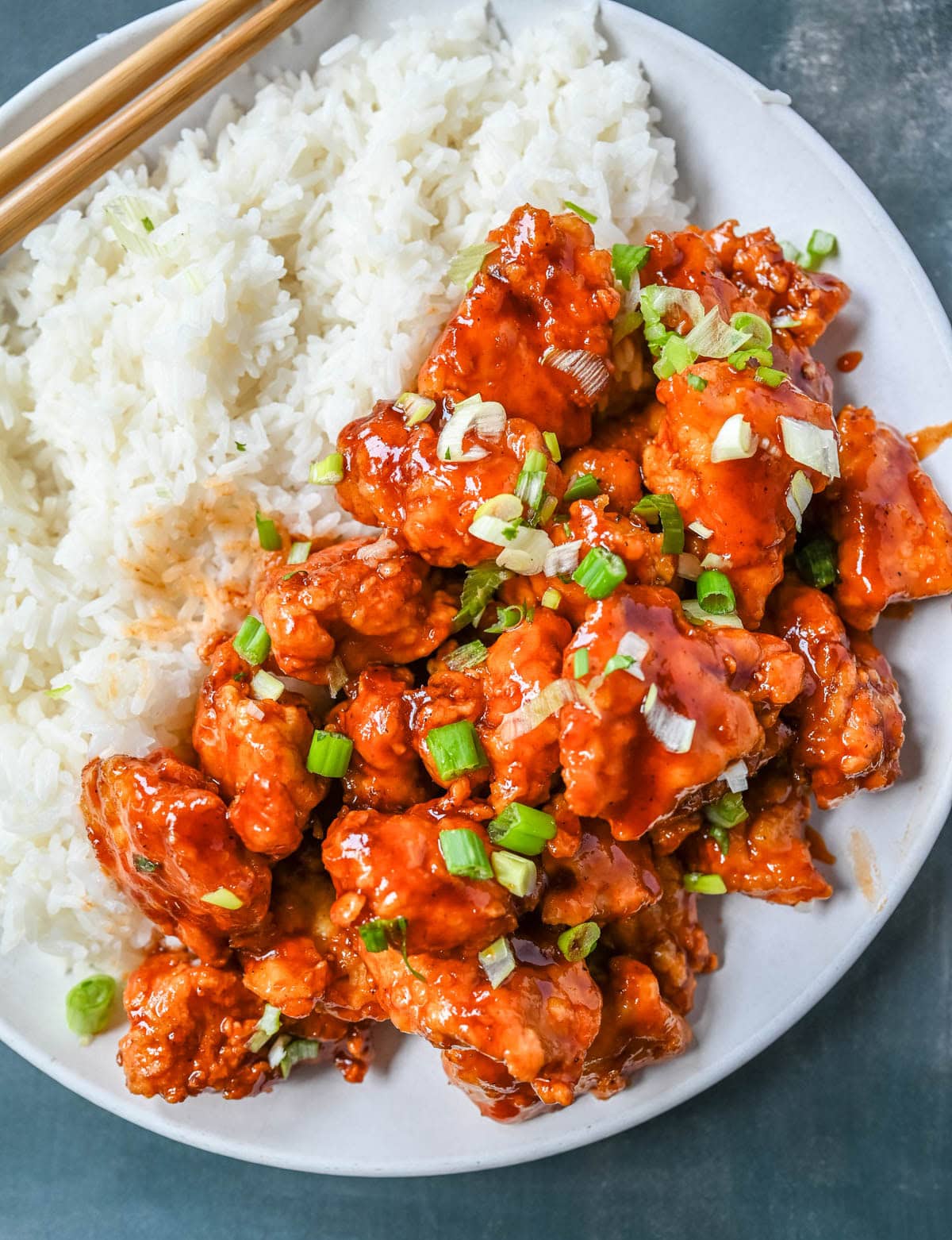 This homemade Honey Sriracha Chicken features tender chicken pieces fried until crispy and covered in a sticky honey sriracha glaze. The combination of honey, garlic, soy sauce, and sriracha creates the ultimate sweet heat flavor. This sticky chicken is way better than takeout!