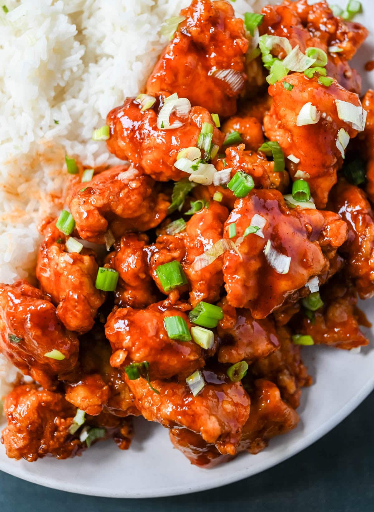 This homemade Honey Sriracha Chicken features tender chicken pieces fried until crispy and covered in a sticky honey sriracha glaze. The combination of honey, garlic, soy sauce, and sriracha creates the ultimate sweet heat flavor. This sticky chicken is way better than takeout!