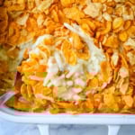 This creamy, cheesy funeral potatoes recipe is the ultimate comfort food casserole made with hash browns, sour cream, cheddar, and a rich homemade sauce. Topped with a crispy cornflake and potato chip crust, it’s perfect for Easter, potlucks, and family dinners. Learn how to make the best funeral potatoes from scratch -- no canned soup needed.