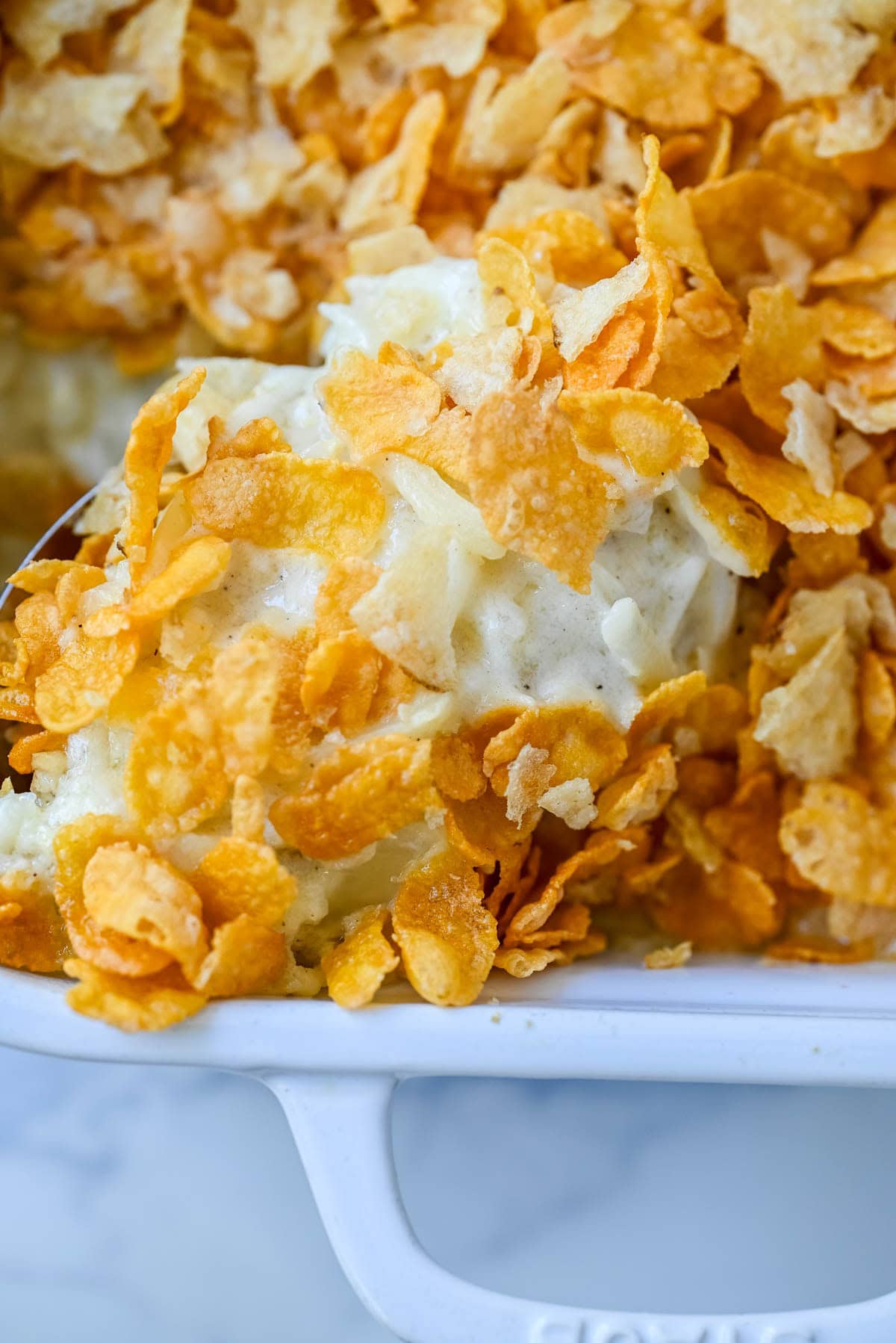 This creamy, cheesy funeral potatoes recipe is the ultimate comfort food casserole made with hash browns, sour cream, cheddar, and a rich homemade sauce. Topped with a crispy cornflake and potato chip crust, it’s perfect for Easter, potlucks, and family dinners. Learn how to make the best funeral potatoes from scratch -- no canned soup needed.