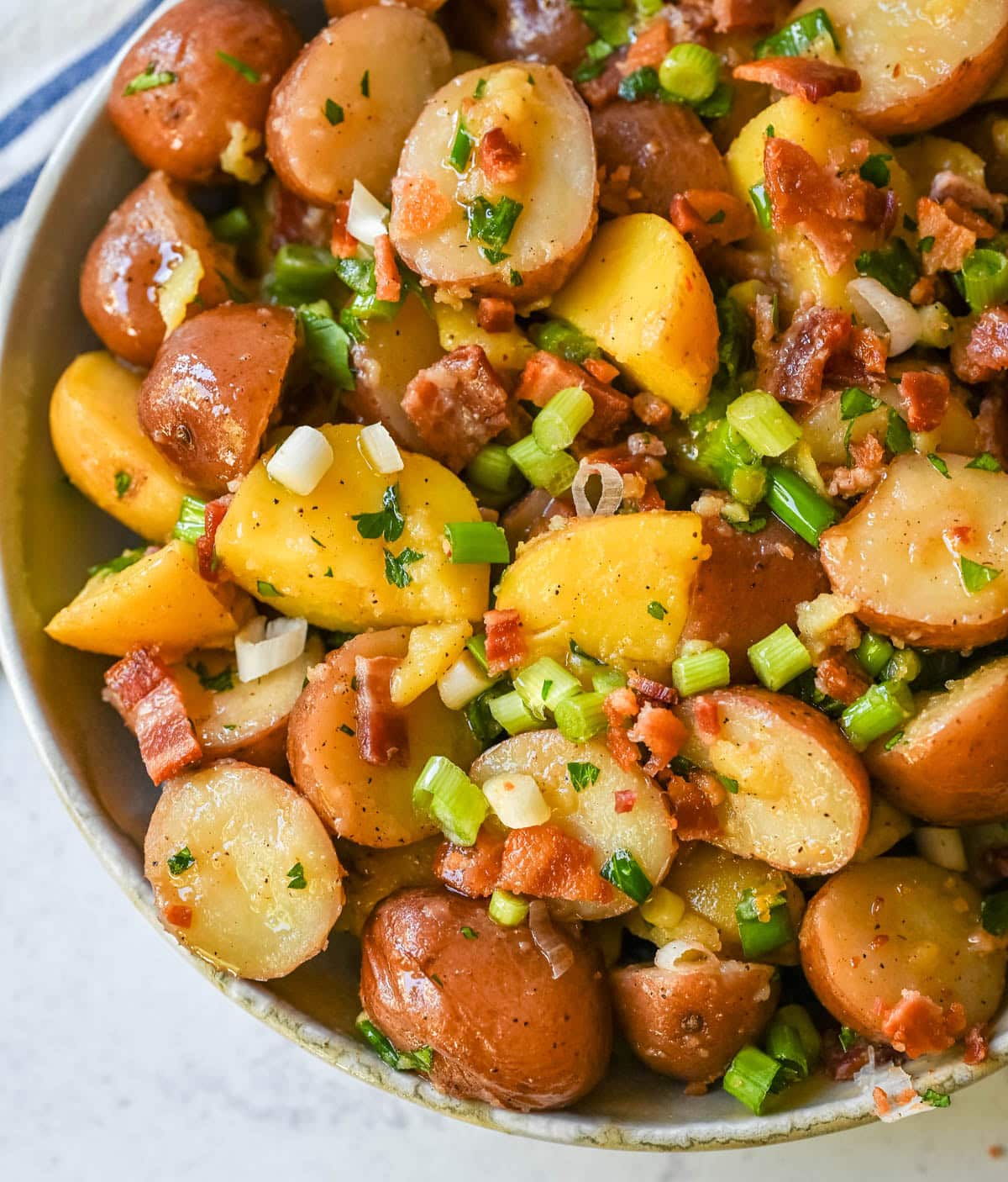 This no mayo potato salad is the perfect summer side dish -- light, tangy, and packed with fresh herbs. Made with a simple olive oil and vinegar dressing, this vinaigrette-based potato salad soaks into tender potatoes for incredible flavor without the heaviness of mayonnaise. Inspired by classic German potato salad, this version is fresh and healthy. If you’re looking for a potato salad without mayonnaise that’s full of flavor, this is the one for you!