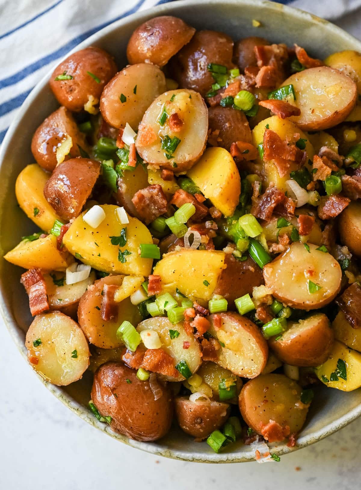 This no mayo potato salad is the perfect summer side dish -- light, tangy, and packed with fresh herbs. Made with a simple olive oil and vinegar dressing, this vinaigrette-based potato salad soaks into tender potatoes for incredible flavor without the heaviness of mayonnaise. Inspired by classic German potato salad, this version is fresh and healthy. If you’re looking for a potato salad without mayonnaise that’s full of flavor, this is the one for you!