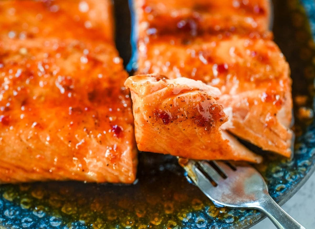The Best Honey Garlic Salmon glazed with a soy honey garlic sauce. Flaky salmon on a plate.