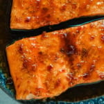The Best Honey Garlic Glazed Salmon (Sticky, Sweet & Spicy) is the most incredible easy weeknight dinner recipe that comes together in just one pan in under 20 minutes from start to finish. Sticky sweet and garlicky, this glazed salmon recipe is hands down the most addicting salmon you will ever make coated in a rich homemade honey garlic sauce made with butter, soy sauce, fresh lemon juice, and a kick of chili garlic sauce that takes every single bite completely over the top.