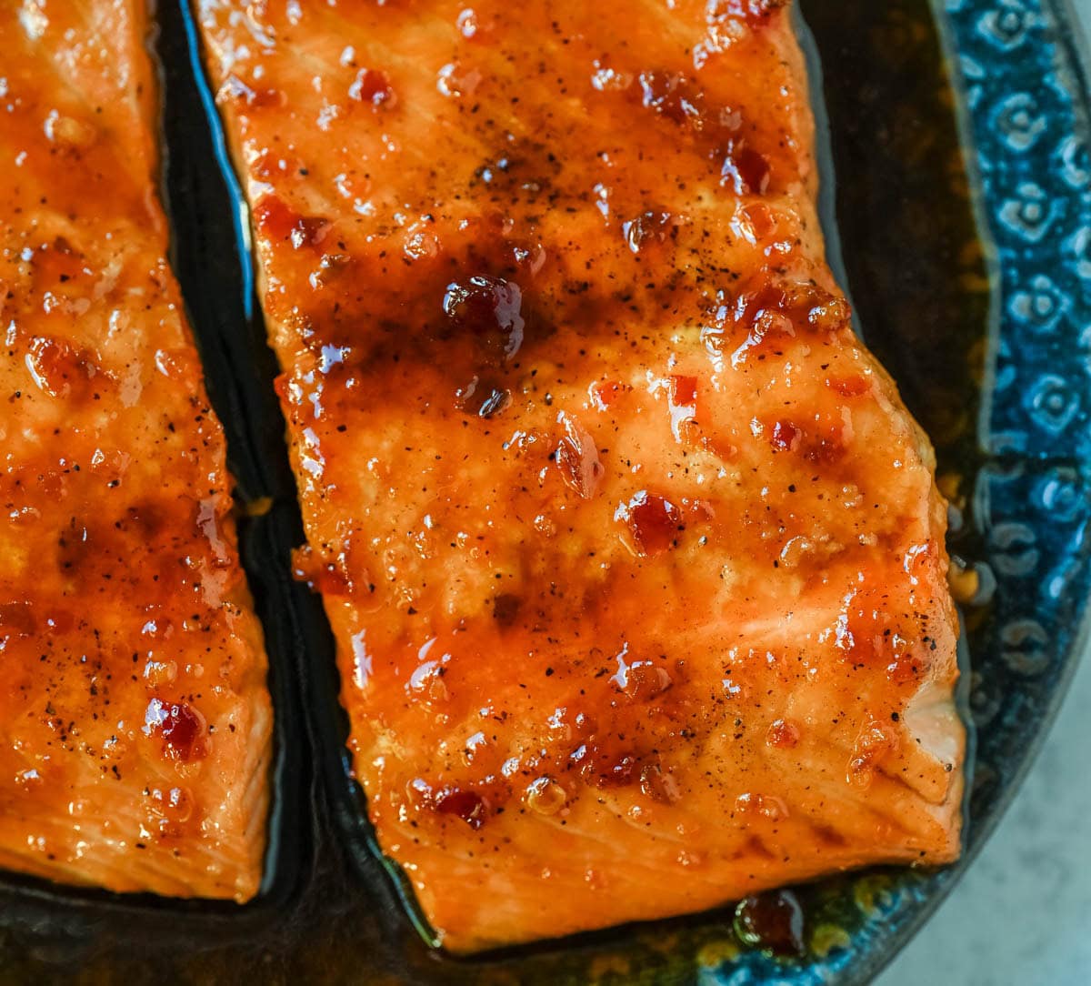 The Best Honey Garlic Glazed Salmon (Sticky, Sweet & Spicy) is the most incredible easy weeknight dinner recipe that comes together in just one pan in under 20 minutes from start to finish. Sticky sweet and garlicky, this glazed salmon recipe is hands down the most addicting salmon you will ever make coated in a rich homemade honey garlic sauce made with butter, soy sauce, fresh lemon juice, and a kick of chili garlic sauce that takes every single bite completely over the top.