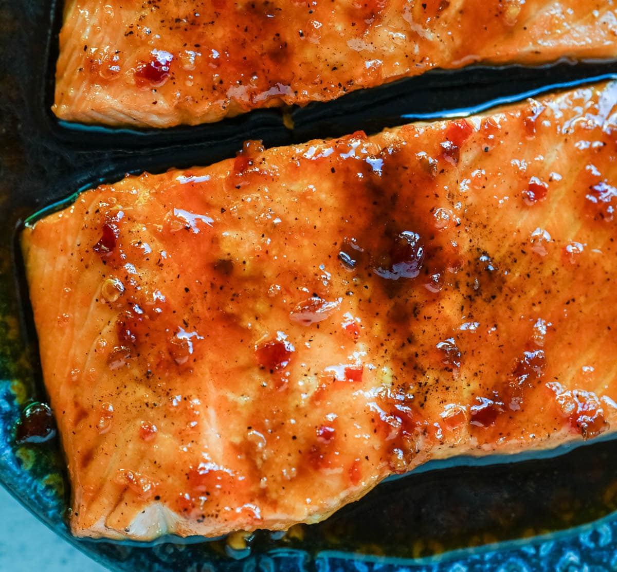 The Best Honey Garlic Glazed Salmon (Sticky, Sweet & Spicy) is the most incredible easy weeknight dinner recipe that comes together in just one pan in under 20 minutes from start to finish. Sticky sweet and garlicky, this glazed salmon recipe is hands down the most addicting salmon you will ever make coated in a rich homemade honey garlic sauce made with butter, soy sauce, fresh lemon juice, and a kick of chili garlic sauce that takes every single bite completely over the top.