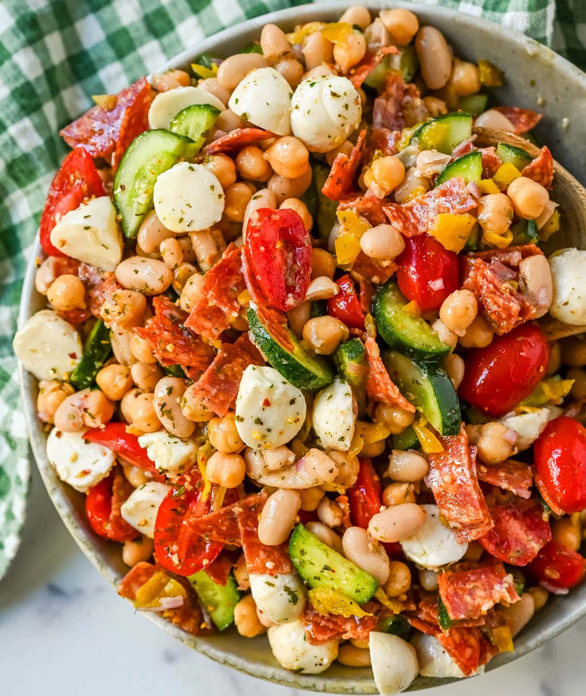 This Italian dense bean salad is the TikTok viral high protein meal prep recipe that has taken over the internet and for very good reason. Loaded with chickpeas, white beans, crisp Persian cucumbers, cherry tomatoes, creamy mozzarella, savory pepperoni or salami, and tangy pepperoncinis all tossed in a homemade Italian dressing, every single bite is packed with incredible flavor that gets better the longer it sits.