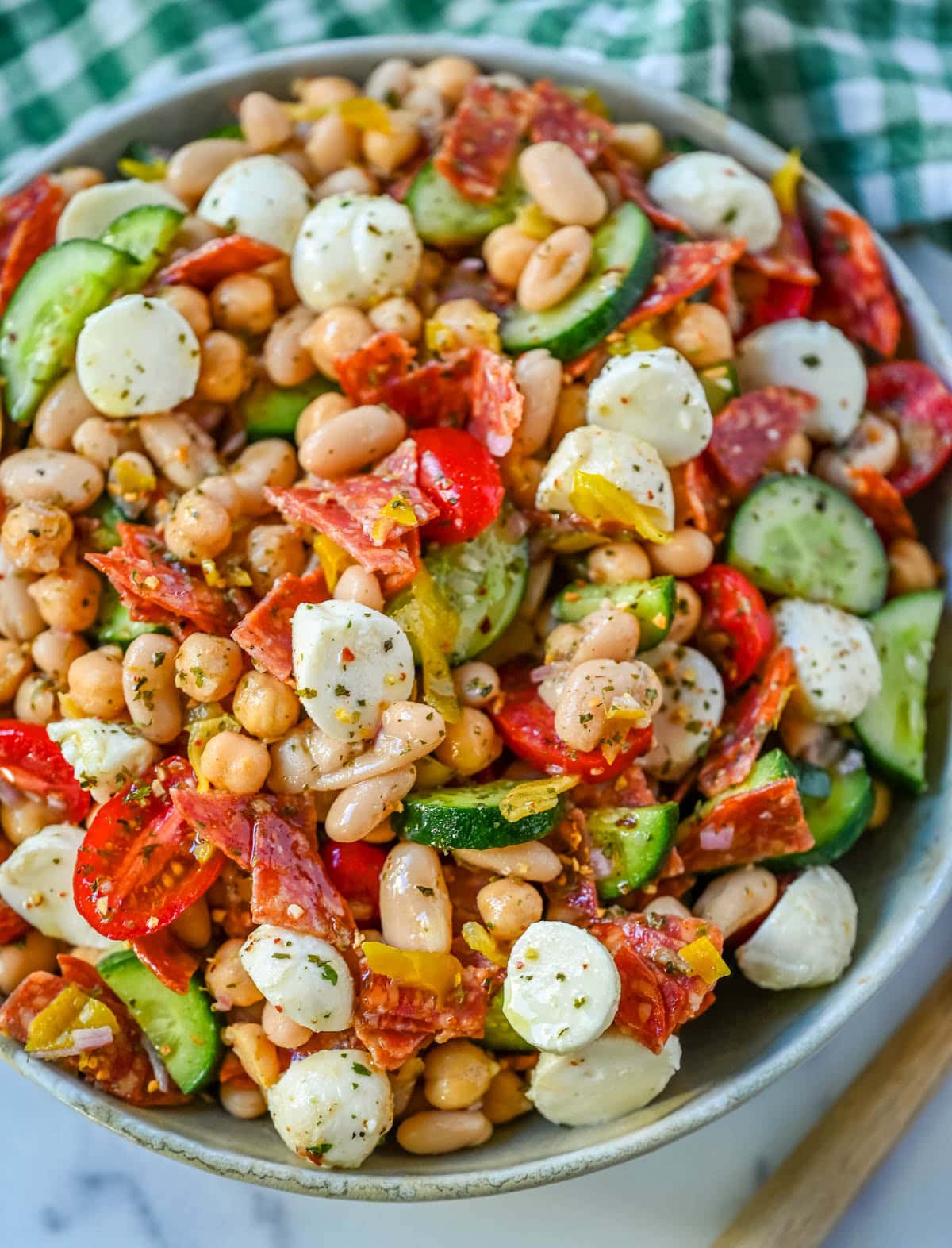 This Italian dense bean salad is the TikTok viral high protein meal prep recipe that has taken over the internet and for very good reason. Loaded with chickpeas, white beans, crisp Persian cucumbers, cherry tomatoes, creamy mozzarella, savory pepperoni or salami, and tangy pepperoncinis all tossed in a homemade Italian dressing, every single bite is packed with incredible flavor that gets better the longer it sits.