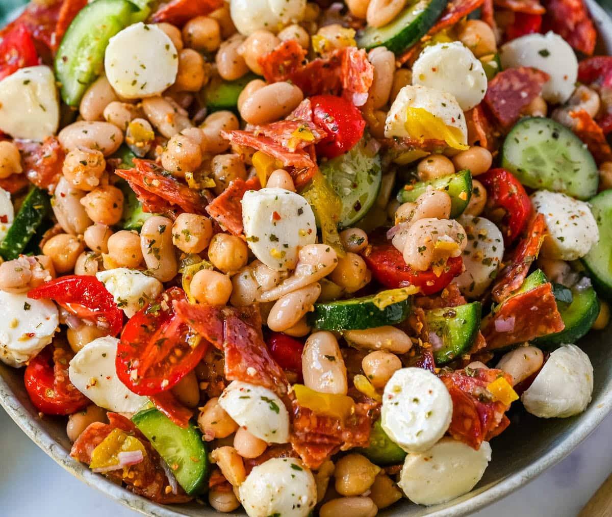 This Italian dense bean salad is the TikTok viral high protein meal prep recipe that has taken over the internet and for very good reason. Loaded with chickpeas, white beans, crisp Persian cucumbers, cherry tomatoes, creamy mozzarella, savory pepperoni or salami, and tangy pepperoncinis all tossed in a homemade Italian dressing, every single bite is packed with incredible flavor that gets better the longer it sits.