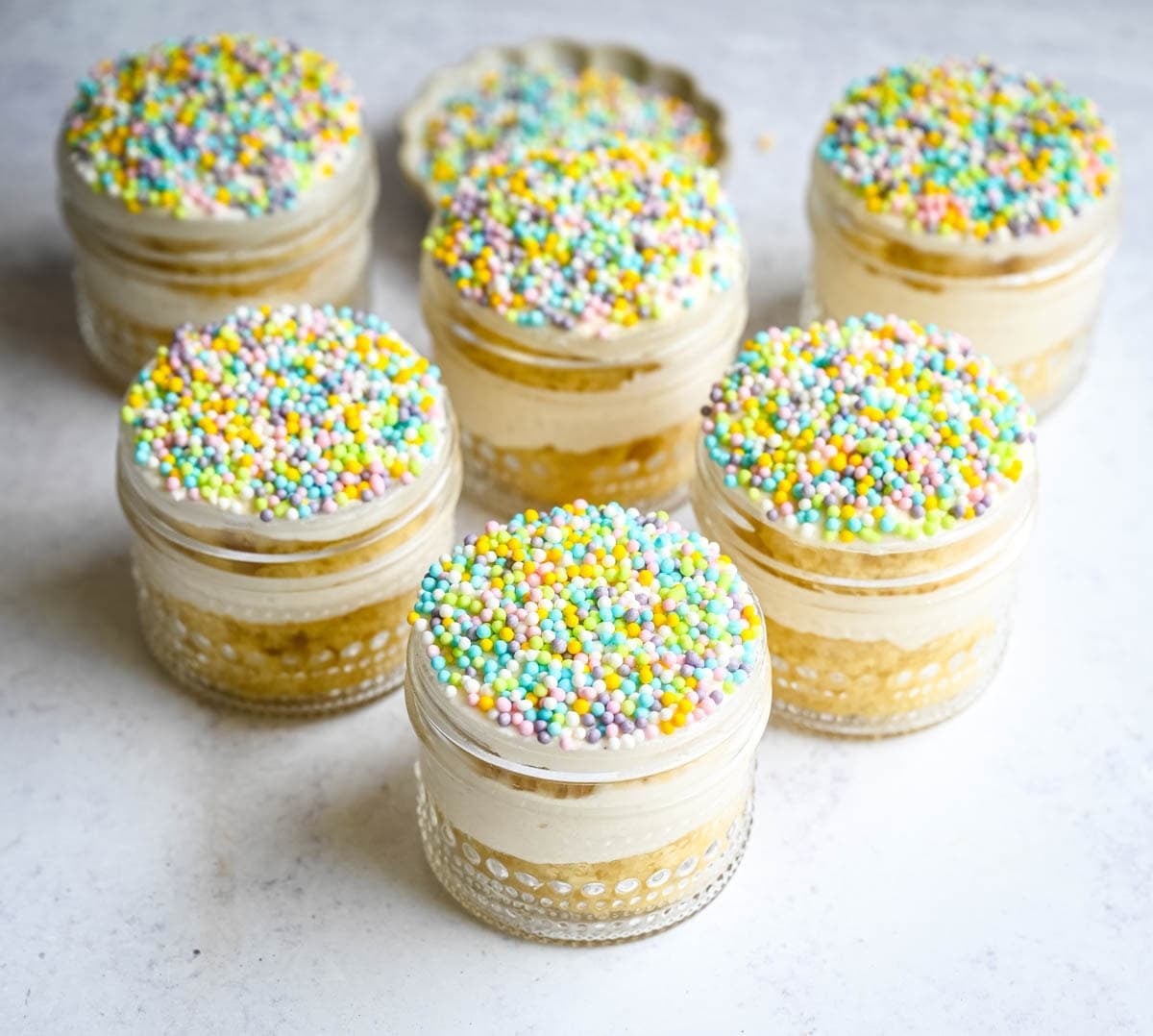 Dot Cake Recipe (Cake in a jar). This viral dot cake recipe brings the NYC sprinkle cake trend straight to your kitchen — no trip to Butterfield Market required! Soft, buttery homemade yellow cake layered in a cup, topped with creamy vanilla buttercream, and completely coated in rainbow nonpareil sprinkles for that irresistible crunch. This easy homemade version is better than any boxed mix recipe you'll find — and takes less than an hour to make!