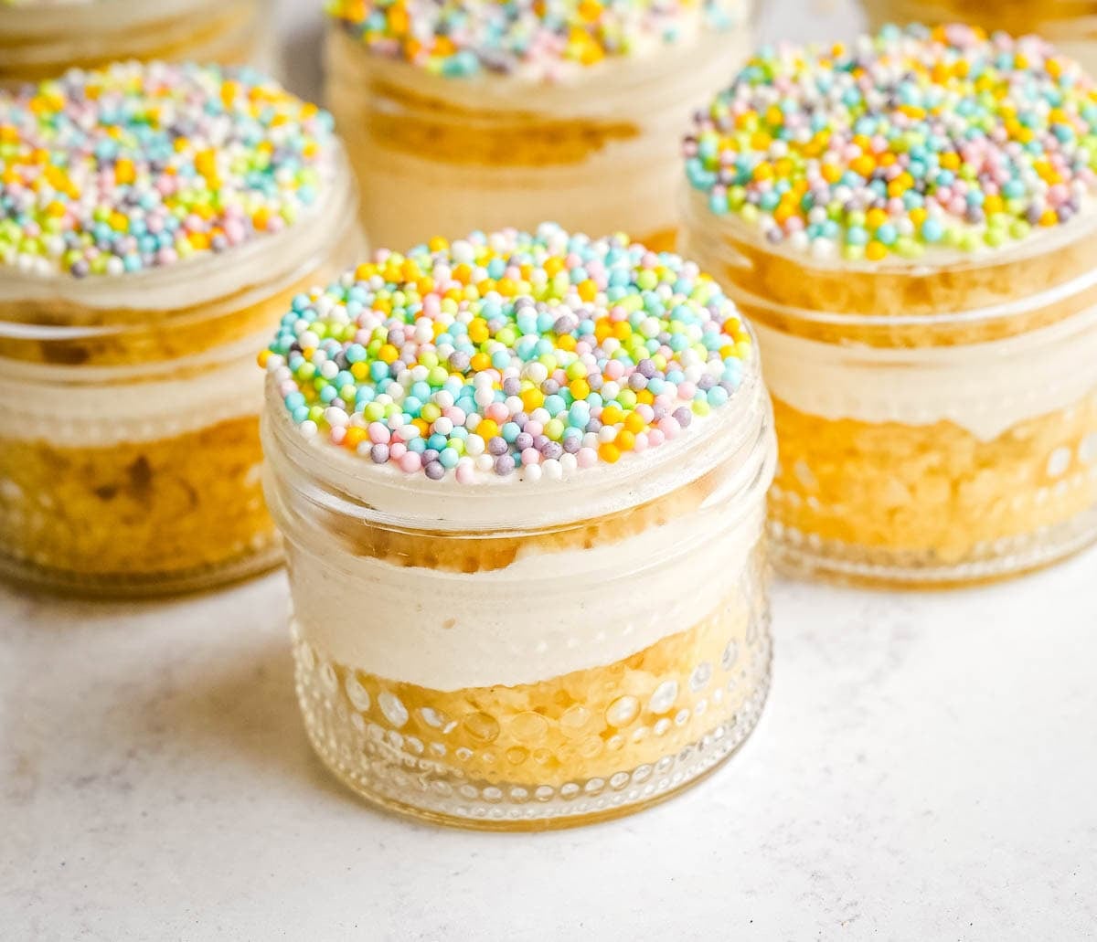 This viral dot cake recipe brings the NYC sprinkle cake trend straight to your kitchen — no trip to Butterfield Market required! Soft, buttery homemade yellow cake layered in a cup, topped with creamy vanilla buttercream, and completely coated in rainbow nonpareil sprinkles for that irresistible crunch. This easy homemade version is better than any boxed mix recipe you'll find — and takes less than an hour to make!